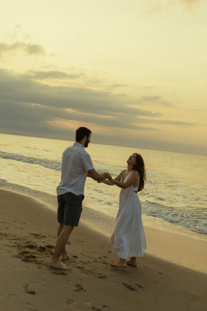 Couple dancing on the beach at sunrise